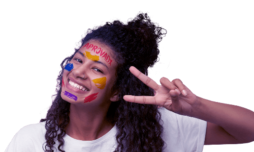 Pessoa com tinta no rosto e com a palavra 'aprovadx' na testa sorrindo